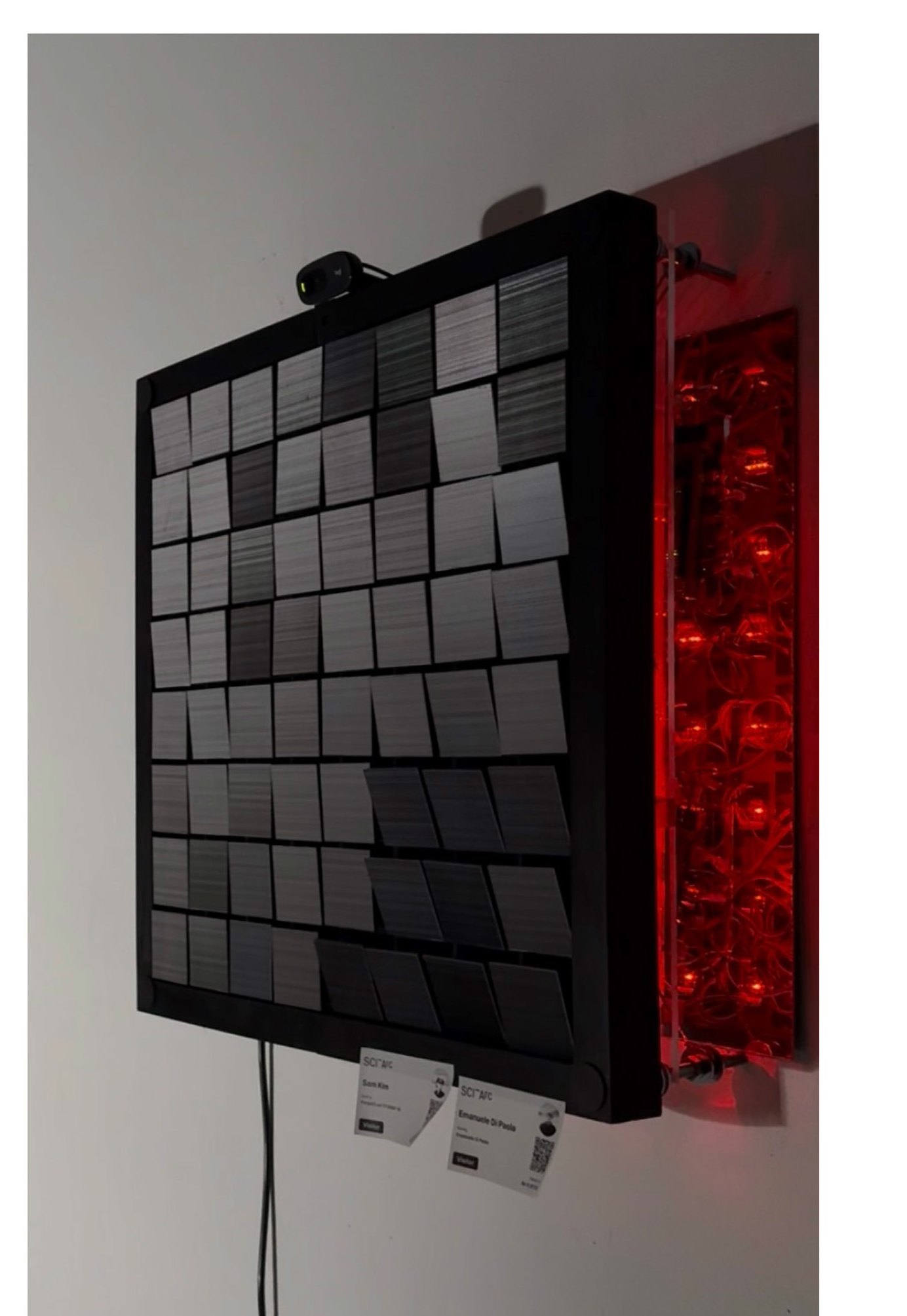 Mechanical Mirror front view, offline state — 64 lenticular tile panels in a steel frame with red-lit electronics bay behind