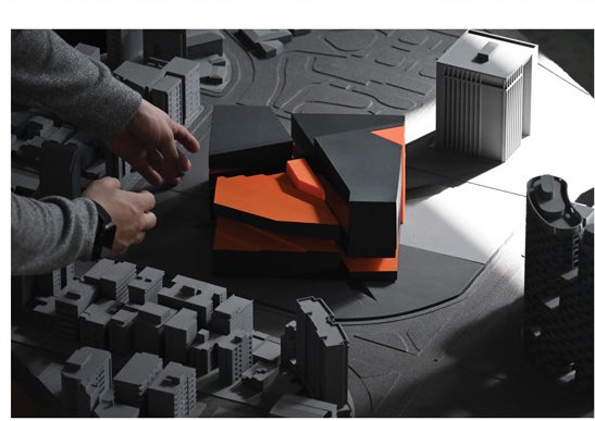 Hands adjusting the massing model in the site context